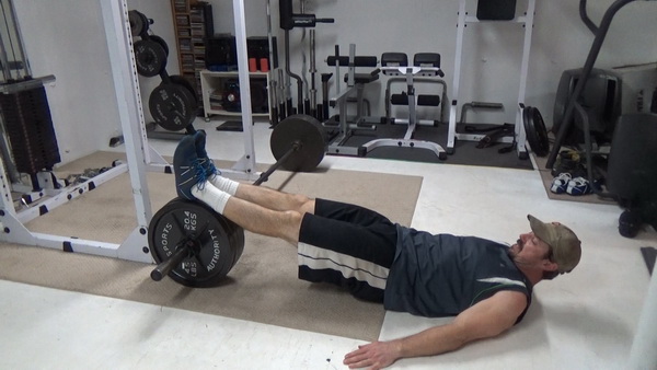 Roll-Up Barbell Plate Leg Curls Start